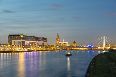 Germany, North Rhine-Westphalia, Cologne, Rheinau harbour with crane houses, Cologne Cathedral and Severins Bridge in the evening - WGF000523