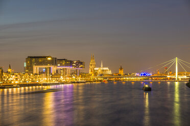 Germany, North Rhine-Westphalia, Cologne, Rheinau harbour with crane houses, Cologne Cathedral and Severins Bridge in the evening - WG000524