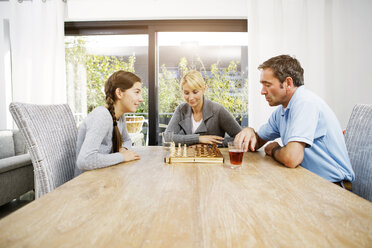 Vater und Tochter spielen zu Hause Schach, die Mutter schaut zu - GDF000600