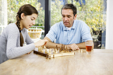 Father and daughter playing chess at home - GDF000604