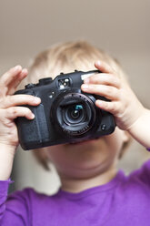 Das Gesicht eines kleinen Mädchens hinter der Digitalkamera - JFEF000535