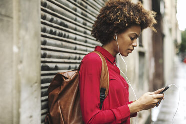 Young woman with bck pack hearing music with earphones - EBSF000366