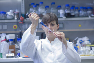 Junge Naturwissenschaftlerin bei der Arbeit in einem biologischen Labor - SGF001084