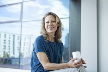 Portrait of smiling mature woman at her apartment - RBF002045