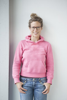 Portrait of smiling mature woman wearing pink hooded jacket - RBF002055