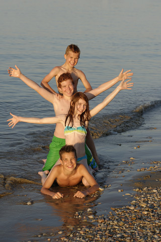 Italien, vier Kinder in einer Reihe an der Strandpromenade, lizenzfreies Stockfoto