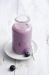 Glass of blueberry smoothie on white wood - ODF000872