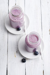 Zwei Gläser mit Blaubeer-Smoothie auf weißem Holz - ODF000873