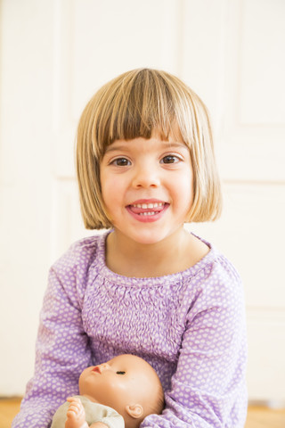 Portrait of smiling little girl with doll stock photo