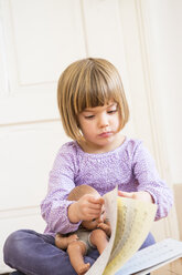 Porträt eines kleinen Mädchens, das in einem Liederbuch blättert - LVF002304