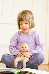Porträt eines singenden kleinen Mädchens mit Puppe und Liederbuch - LVF002312