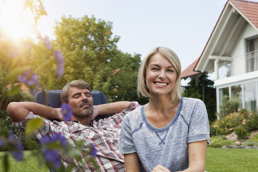 Glückliches reifes Paar auf Liegestuhl im Garten - RBF001918