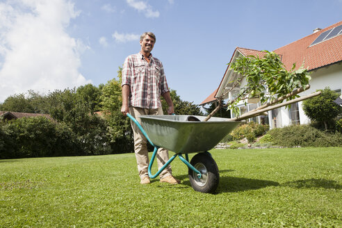 Mann mit Schubkarre im Garten - RBF001920