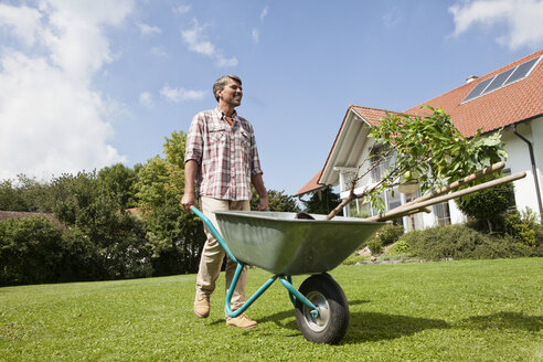Man with wheelbarrow in garden - RBF001921