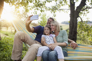 Happy family taking selfie in hammock - RBF001970