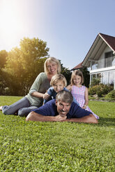 Happy family lying on lawn in garden - RBF001986