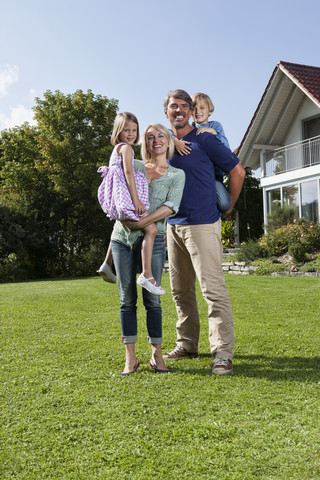 Porträt einer glücklichen Familie im Garten, lizenzfreies Stockfoto