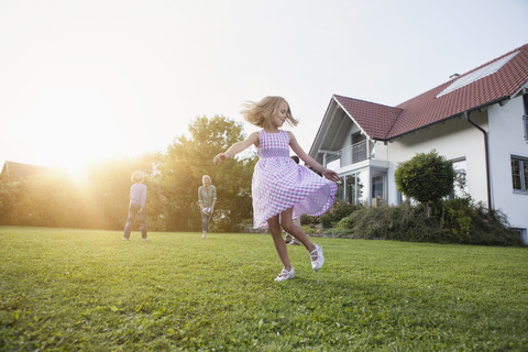 Mädchen in Bewegung mit Familie im Garten, lizenzfreies Stockfoto