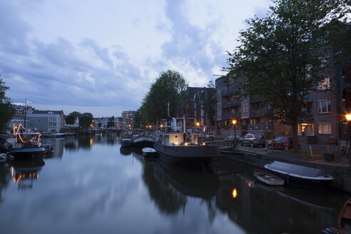 Niederlande, Amsterdam, Blick auf Boote am Stadtkanal und Mehrfamilienhaus im Hintergrund - FCF000482