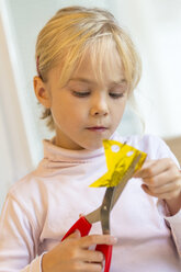 Little girl tinkering with scissors and paper - JFEF000554