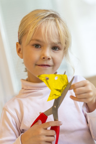 Kleines Mädchen bastelt mit Schere und Papier, lizenzfreies Stockfoto