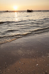 Netherlands, Bloemendaal, people in the ocean at sunset - FCF000515