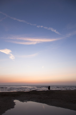 Niederlande, Bloemendaal, Liebespaar am Strand bei Sonnenuntergang, lizenzfreies Stockfoto