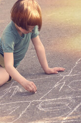 Mädchen zeichnet mit Kreide auf der Straße - LVF002349