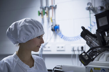 Junge Technikerin betrachtet ein Messgerät in einem Laboratorium - SGF001122