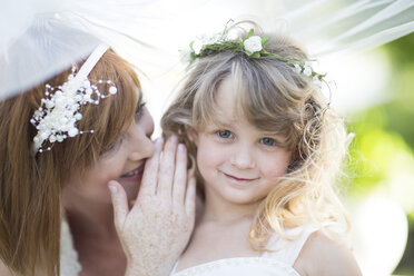 Braut und kleine Brautjungfer flüstern bei der Hochzeit - ZEF002561