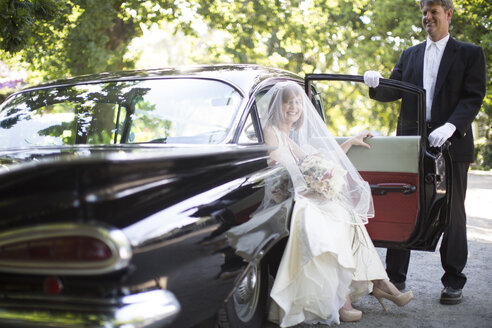 Braut steigt vor ihrer Hochzeit mit Fahrer aus dem Auto aus - ZEF002789