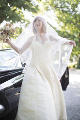 Happy bride outside car - ZEF002567