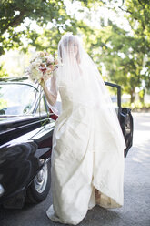 Happy bride outside car - ZEF002569