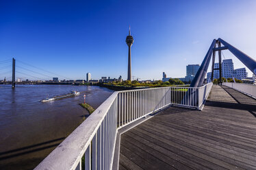 Deutschland, Nordrhein-Westfalen, Düsseldorf, Fußgängerbrücke über den Rhein und Rheinturm im Hintergrund - THAF000936