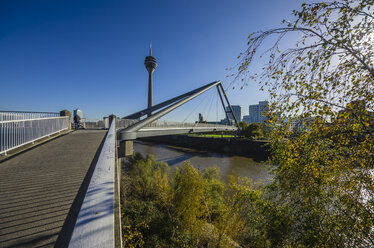 Deutschland, Nordrhein-Westfalen, Düsseldorf, Fußgängerbrücke über den Rhein und Rheinturm im Hintergrund - THAF000937