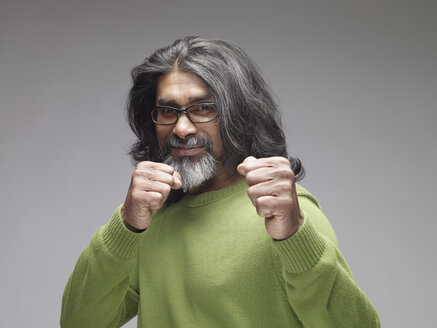 Mature man showing fists, looking confident, portrait - RH000400