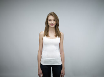 Portrait of smiling young woman in front of grey background - RH000430