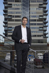 Portrait of smiling businessman with hand in his pocket - RHF000412