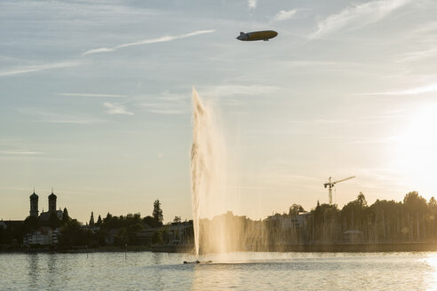 Germany, Baden-Wuerttemberg, Lake Constance, Friedrichshafen, fountain and zeppelin at sunset - SHF001761