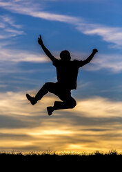 Germany, Silhouette of a man jumping at sunset - STSF000624