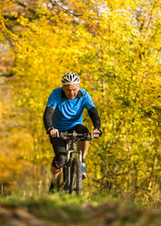 Deutschland, Baden-Württemberg, Älterer Mann beim Mountainbiken im Herbst - STSF000628