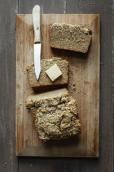 Home-baked glutenfree buckwheat bread, piece of butter and kitchen knife wooden board - EVGF001020