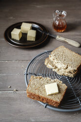 Scheiben selbstgebackenes glutenfreies Buchweizenbrot und ein Stück Butter auf dem Kühlrost - EVGF001021