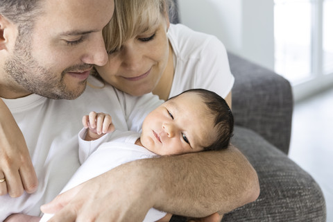 Junges Paar mit neugeborenem Jungen zu Hause, lizenzfreies Stockfoto