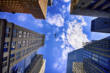 USA, Illinois, Chicago, Blick auf Fassaden von Wolkenkratzern und tief fliegenden Hubschrauber von unten - SMAF000263