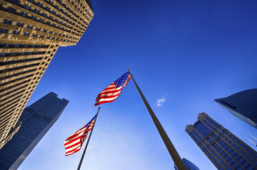 USA, Illinois, Chicago, view to facades of skyscrapers and two American flags from below - SMAF000264