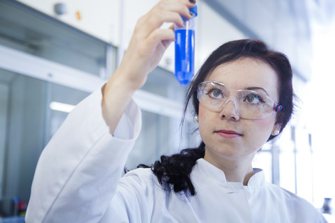 Porträt einer jungen Wissenschaftlerin, die in einem biochemischen Laboratorium arbeitet, lizenzfreies Stockfoto