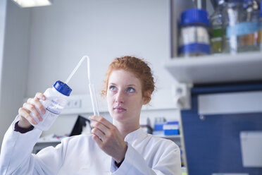 Young female natural scientist working in biochemistry laboratory - SGF001125