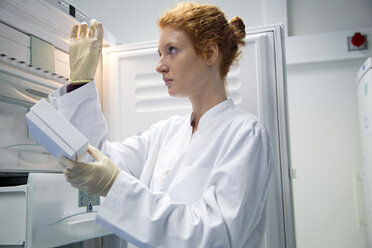 Young female natural scientist controlling a test in biochemistry laboratory - SGF001133
