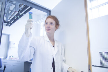 Young female natural scientist watching a test in biochemistry laboratory - SGF001134